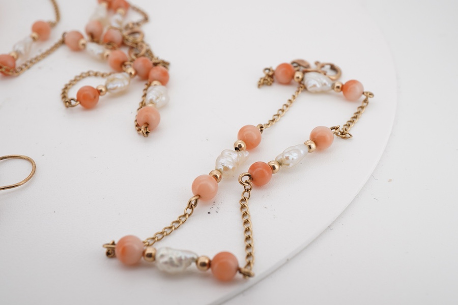 A suite of modern 9ct gold, coral and baroque pearl set jewellery, comprising a necklace, 38cm, a bracelet, 16cm and a pair of drop earrings, together with one other coral bead necklace.